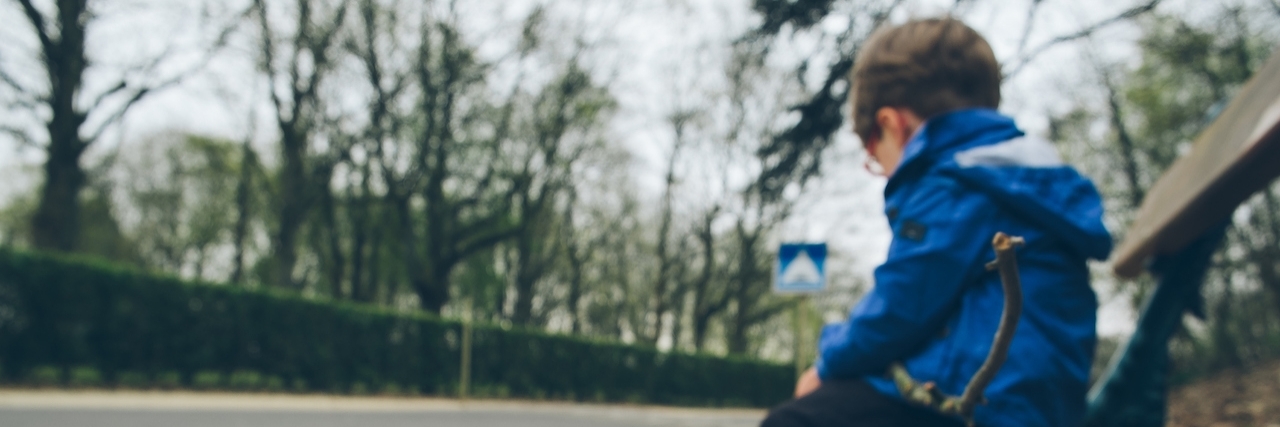 Why Talking to Kids About Mental Health Is Important Sad boy sitting alone on a park bench