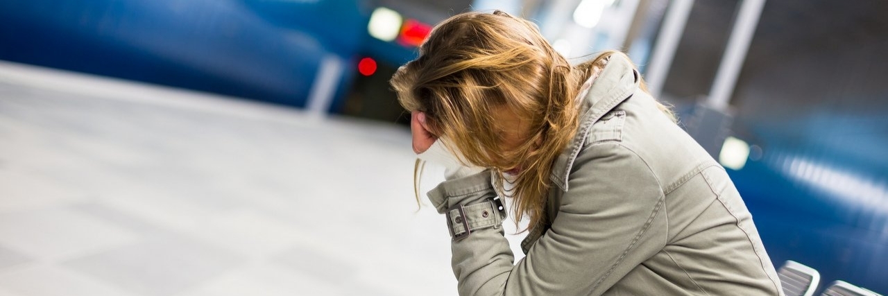 Coping With My Undiagnosed Pain Condition Young woman sitting in a metro station