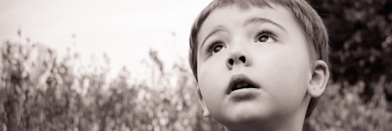 I Was the Parent Who Would Never Medicate My Child, Until I Did Black and white photo of little boy looking up with a tree in the background