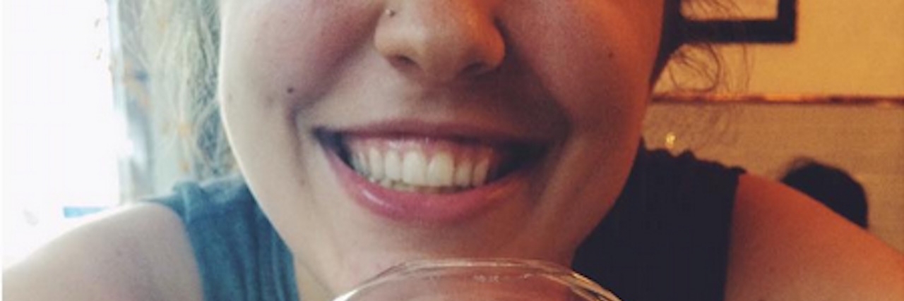 Hiding Your Depression Doesn't Make You Strong Woman smiling behind a cup of icecream.