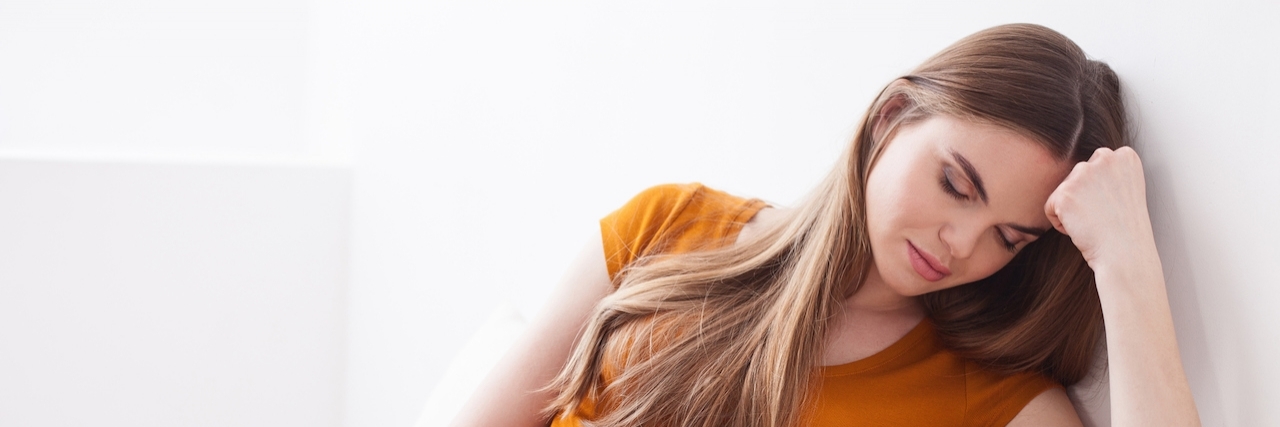 Antenatal Depression: Depressed While Pregnant Pregnant woman closes her eyes while sitting and leaning her forehead on her hand