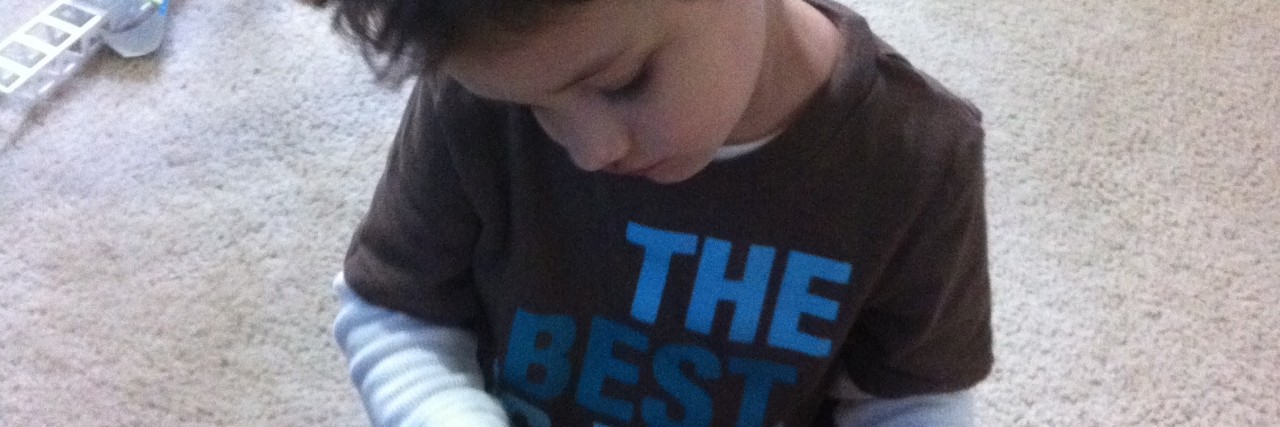 Explaining Birthdays to My Son With Autism Spectrum Disorder young boy playing with a red balloon