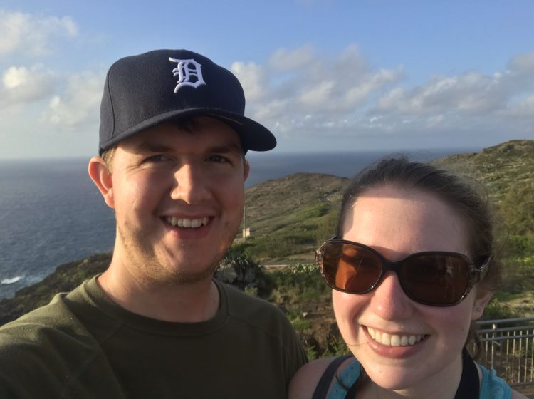 man and woman on mountain with view of ocean