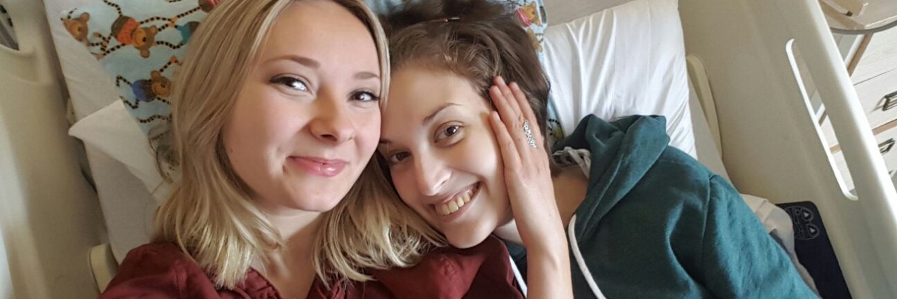 I Mean 'Thank You' When I Say 'Sorry' as Someone With Chronic Illness a woman lays next to Catherine in bed and hugs her