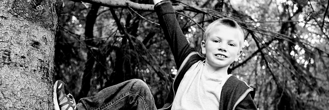 Parenting a Child With Autism and Always Hearing 'Not Quite' boy with autism climbing a tree