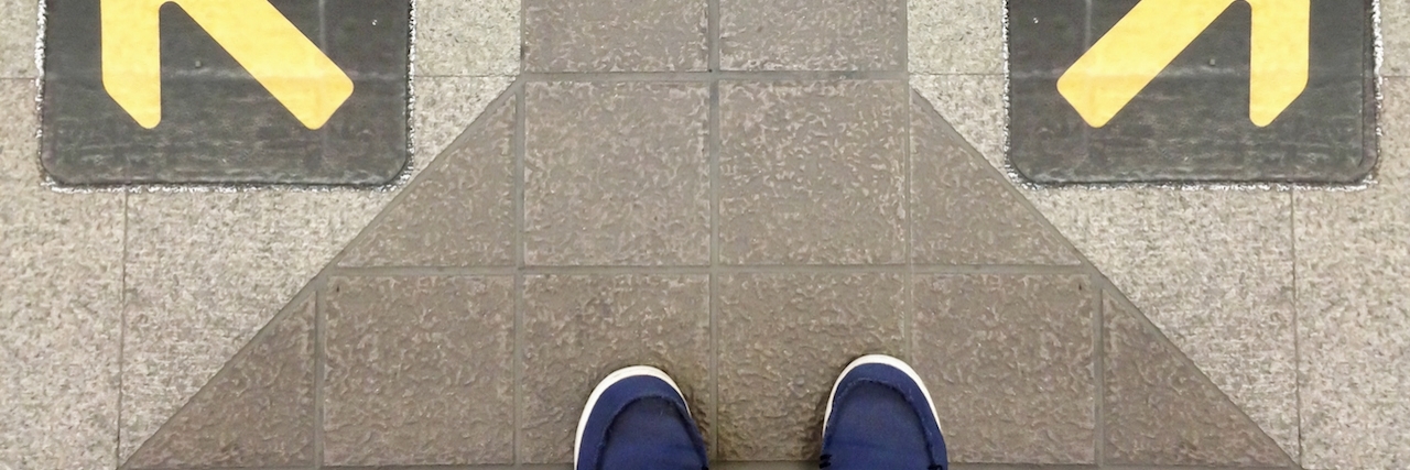 When Happiness Isn't a Choice in the Battle With Depression Two feet on a sidewalk with two opposite-facing arrows painted on it