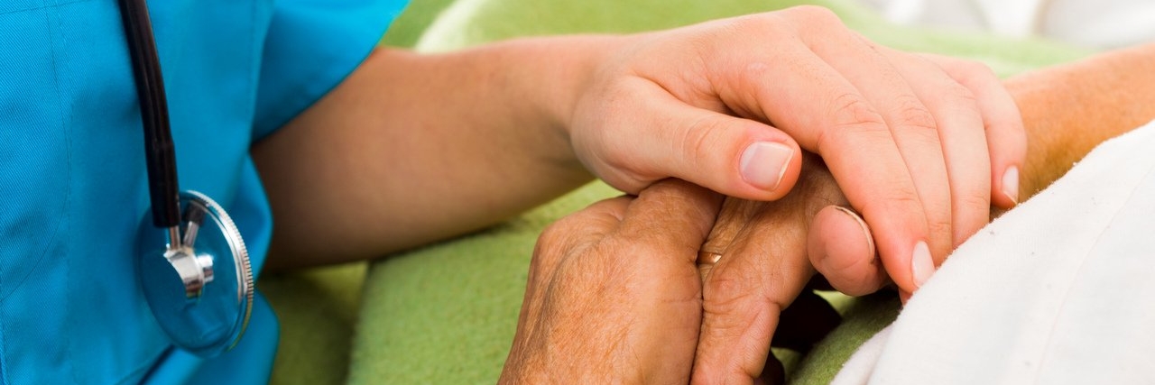 nurse holding patient’s hand