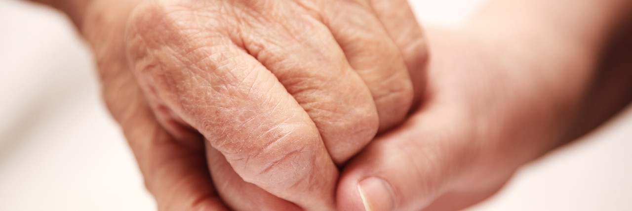 Close up shot of two hands embracing, one person reassuring the other person
