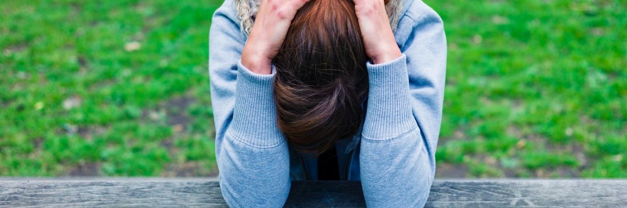 What Chronic Fatigue Really Feels Like woman with her head in her hands