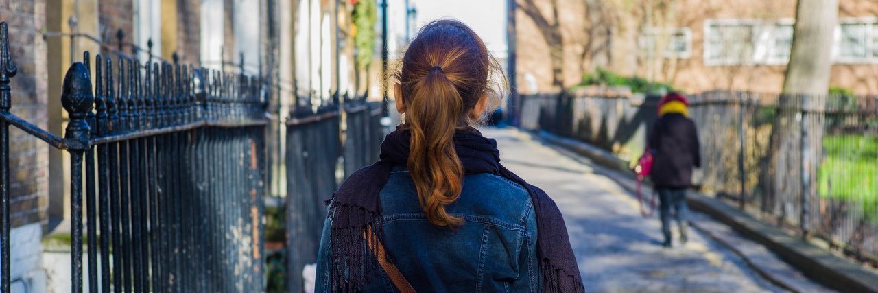 Woman walking cobbled street