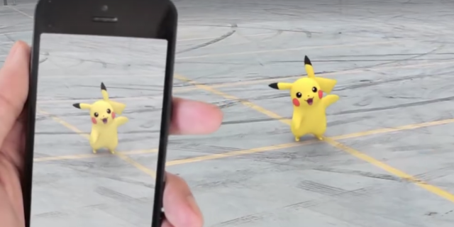 Hand holding phone showing them playing Pokemon Go, and finding Pikachu