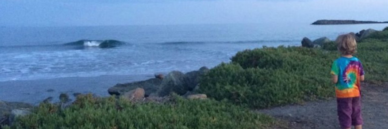 Helping My Child With SPD When He Experiences Sensory Overload Boy standing near water, looking at landscape