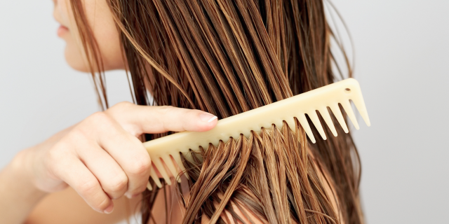 girl running a comb through her wet hair