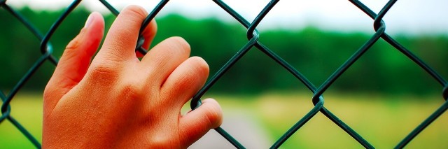 hands on a fence