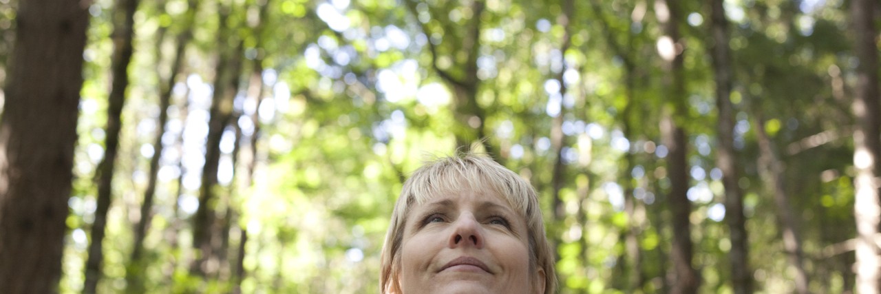 Woman looking at sky during hike in forest