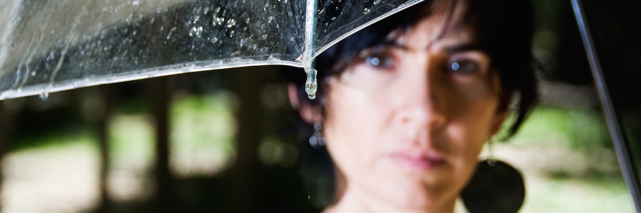 A woman standing under an umbrella