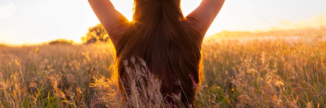 Having Hope With Myalgic Encephalomyelitis and Chronic Fatigue Woman in rural setting at sunrise.