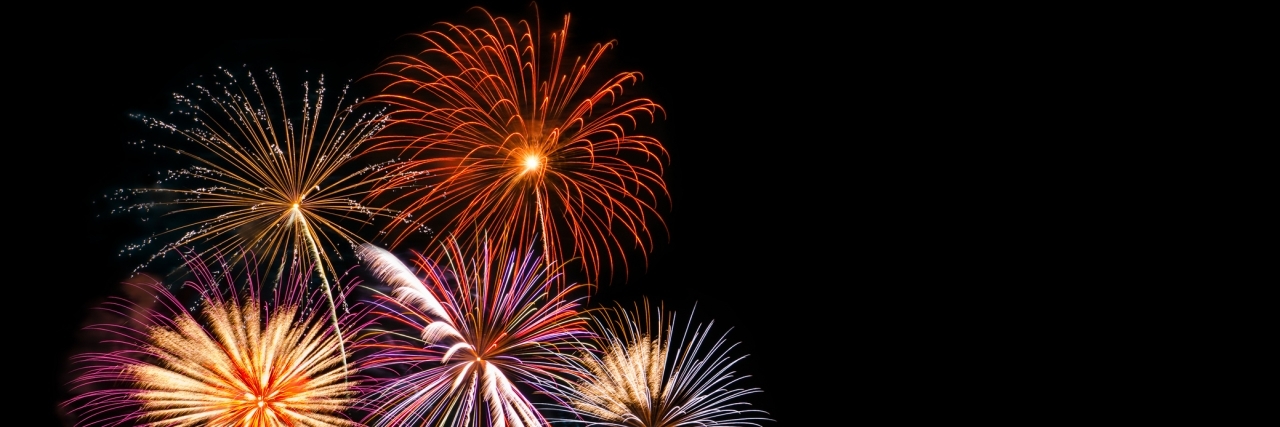 A colorful fireworks show on a black background with copy space on the right.