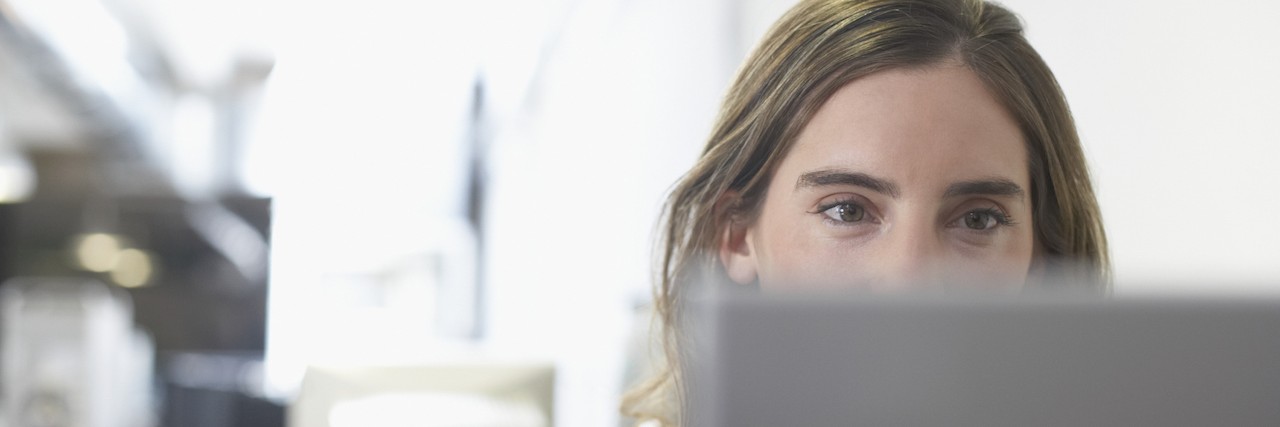 The Anxiety That Arises When Someone Says 'We Need to Talk' businesswoman looking at a laptop in an office