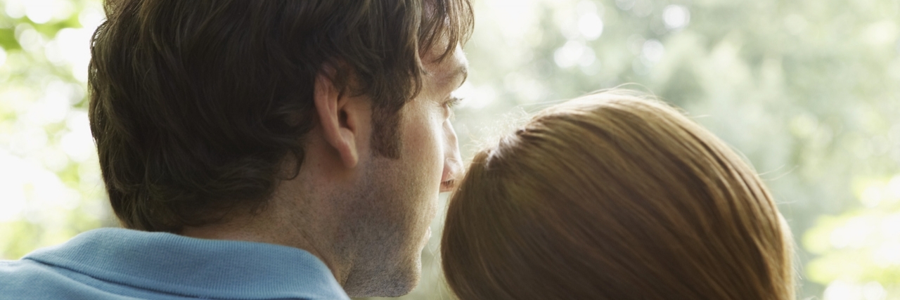 Woman resting head on man's shoulder, rear view, close-up