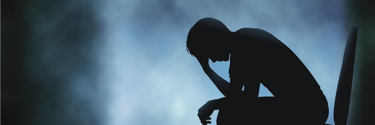 Living With Suicidal Thoughts and Major Depressive Disorder Editable vector silhouette of a man sitting with his head in his hand with background made using a gradient mesh