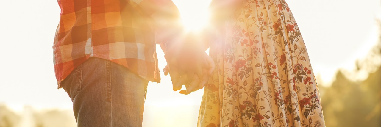 Letter to Future Partner of College Woman With Chronic Illnesses Young couple in love walking in the autumn park holding hands looking in the sunset