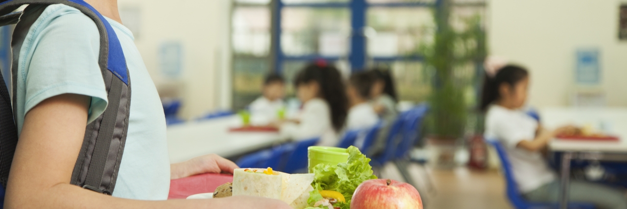 What I Wish Students Understood About Their Peers in Special Education Girl holding food tray in school cafeteria.