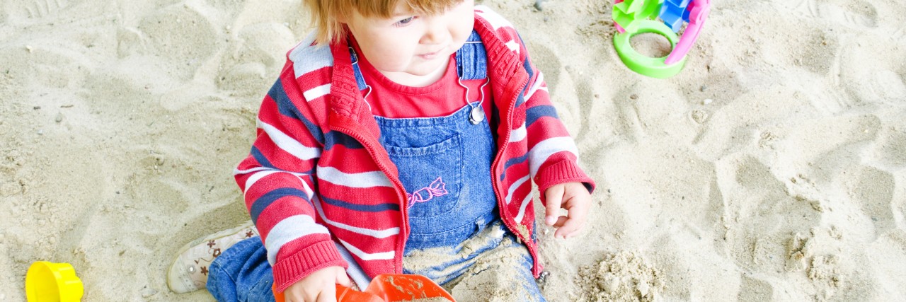 Mom Shares Story of Day With Nonverbal Daughter Little girl playing in the sandbox