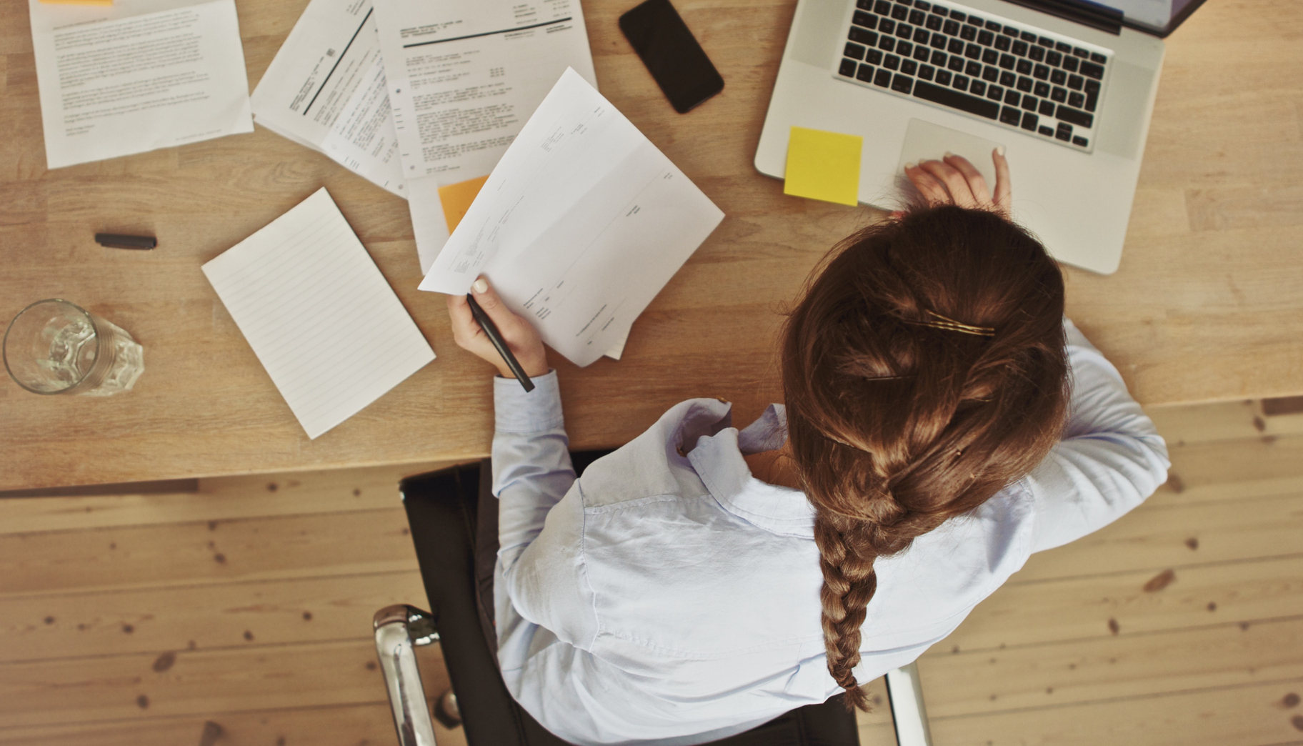 When Multitasking Hides Depression and Anxiety High-angle view of woman working at her desk with paperwork and a laptop