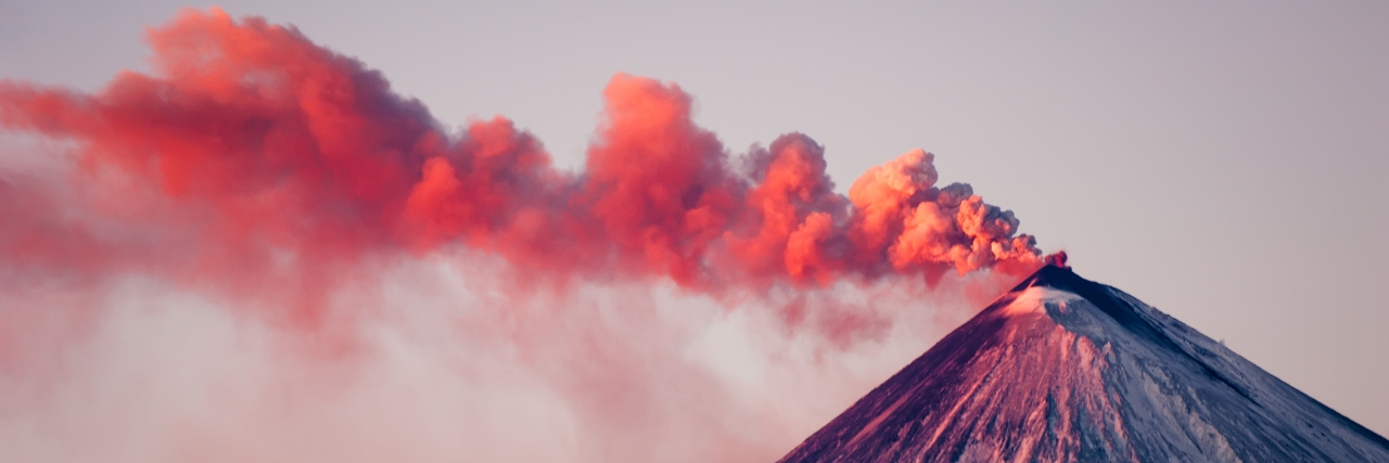 Thick red smoke emerges from the top of the volcano during the eruption at Kamchatka.