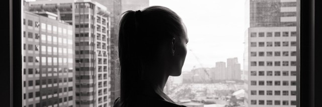 Woman look out of office window thinking.