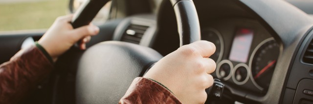woman's hands on the wheel of a car