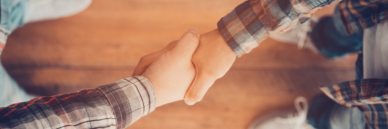 How to Support Someone With a Mental Illness Men shaking hands.