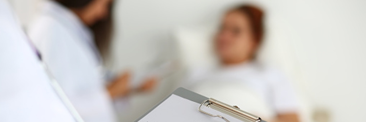 Going to the ER for Inflammatory Bowel Disease woman waiting in ER room while doctor fills out medical forms