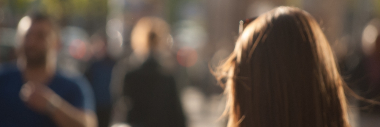 People walking down the street in the evening, beautiful light at sunset. The photo is purposely made out of focus, no faces are recognisible