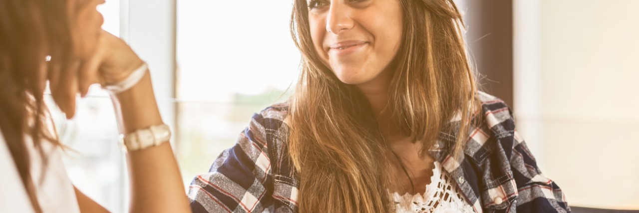 What Friends Should Know About My Social Anxiety Two women looking at each other and smiling while having coffee at a cafe