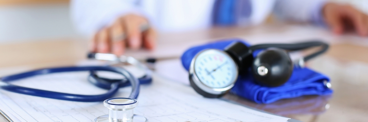 To the Insurance Companies Who Will Decide Whether or Not to Cover My Treatment Medical stethoscope lying on cardiogram chart closeup while medicine doctor working in background. Cardiology care,health, protection, prevention and help. Healthy life or insurance concept