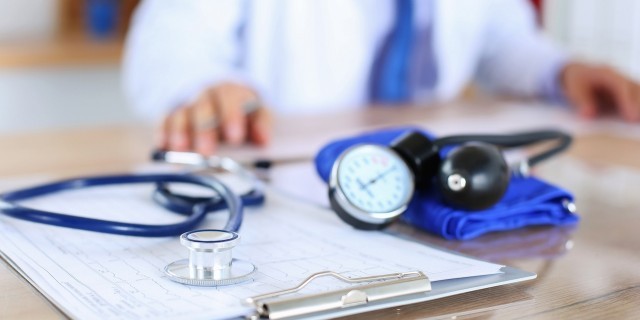 To the Insurance Companies Who Will Decide Whether or Not to Cover My Treatment Medical stethoscope lying on cardiogram chart closeup while medicine doctor working in background. Cardiology care,health, protection, prevention and help. Healthy life or insurance concept