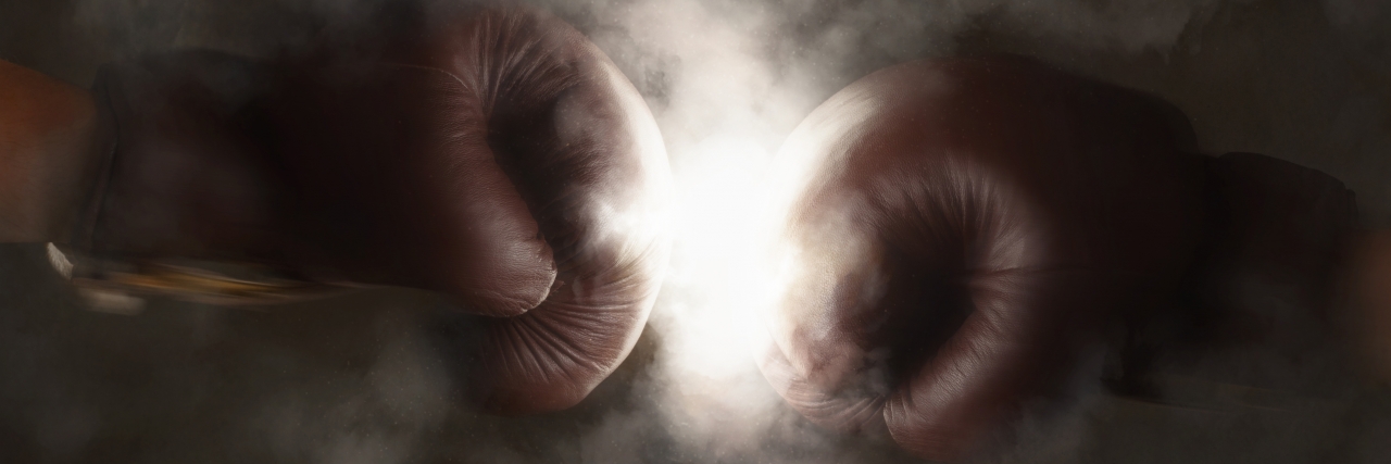 Living With Cerebral Palsy and Graves' Disease Two boxing gloves hit together.