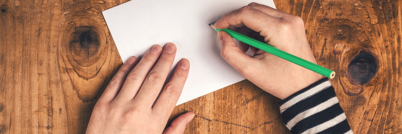 Woman writing recipient address on mailing envelope