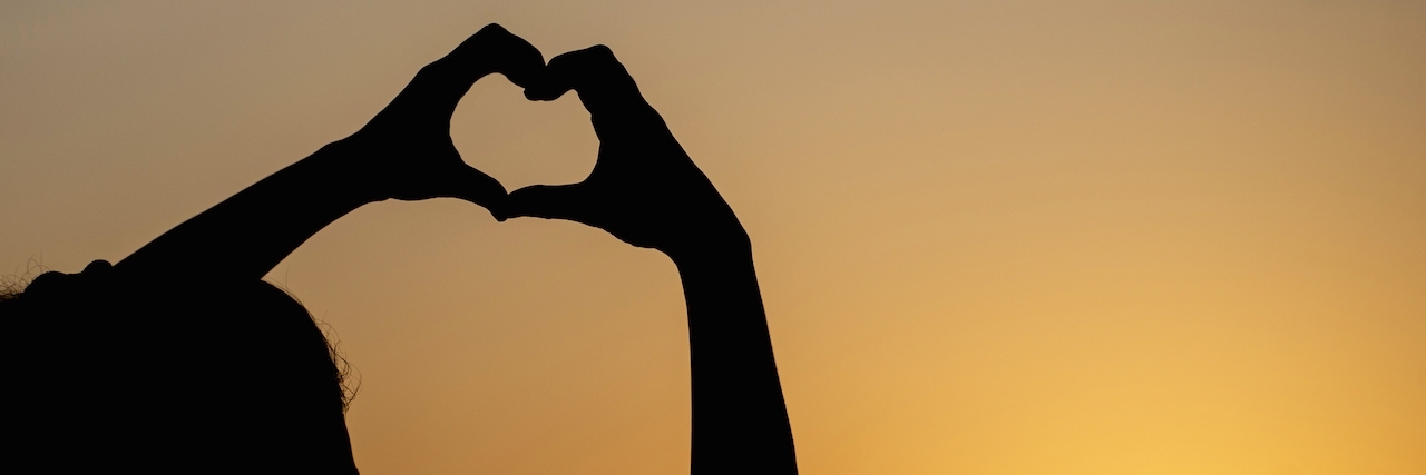 Ways to Stay Positive About Chronic Pain silhouette woman making heart shape with sunset