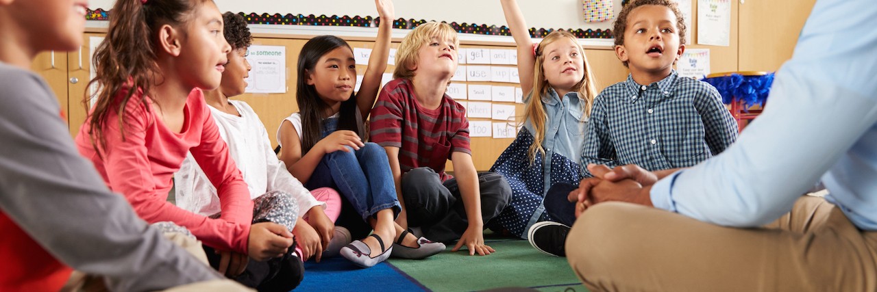 Educating Teachers About Children With Sensory Processing Disorder Elementary school kids and teacher sit on floor