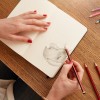 Woman sketching a flower in sketchbook