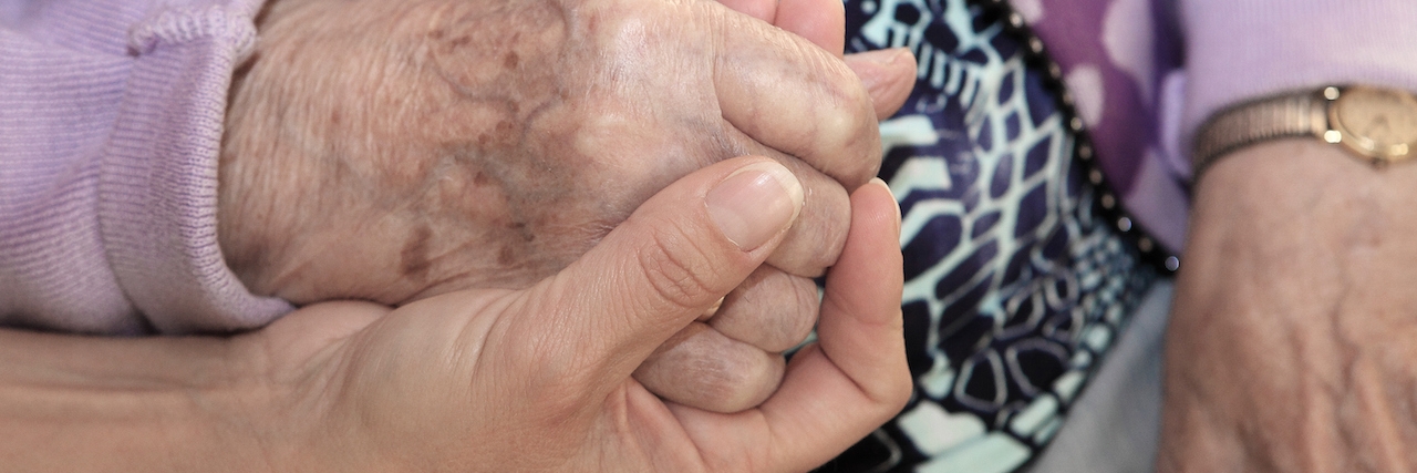 Being a Caregiver to Parents When You Have a Chronic Disease Daughter holding her mother`s hand