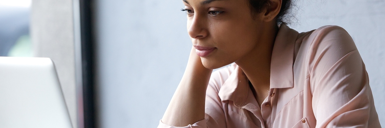 Taking Classes Online Because of Social Anxiety Woman at desk, looking at laptop