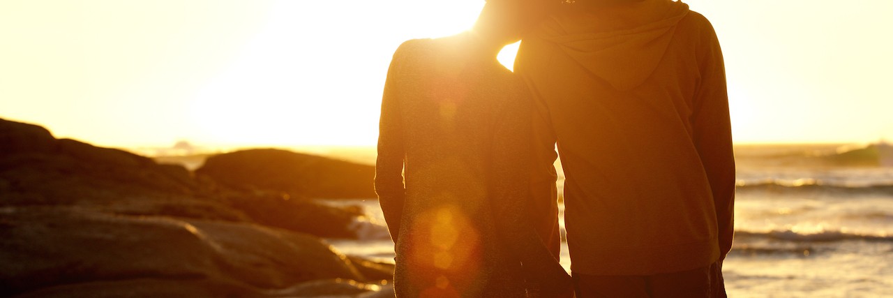 What's More Powerful Than My Anxiety Couple holding hands at the beach watching the sunset
