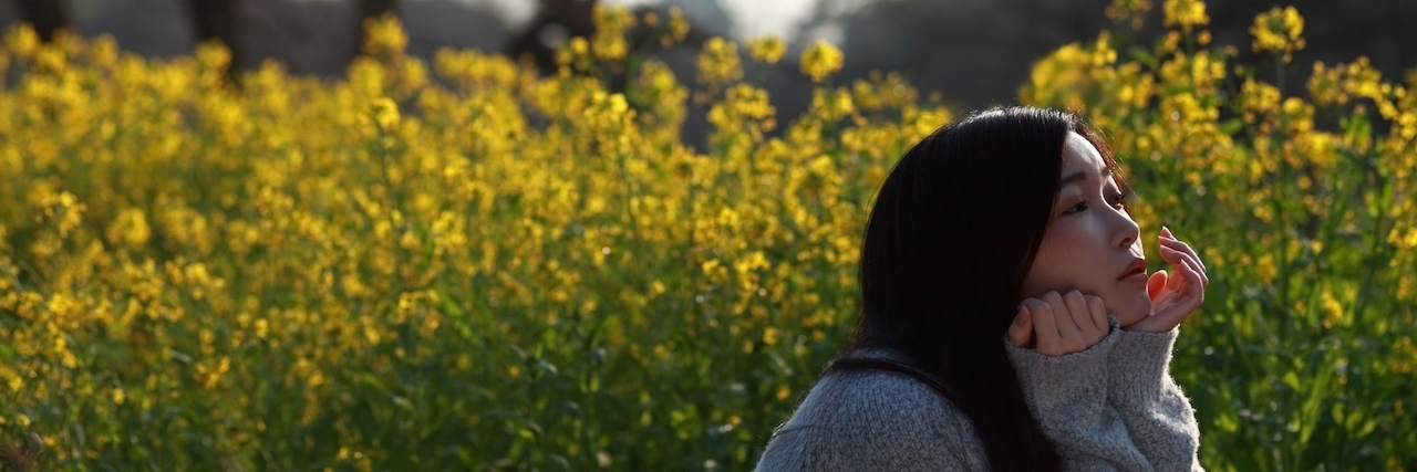 woman in field of yellow flowers