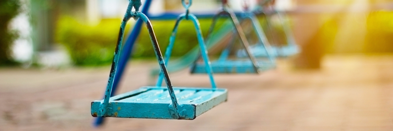 What It's Like Living With Dissociative Disorder Closeup of swings in the park of morning