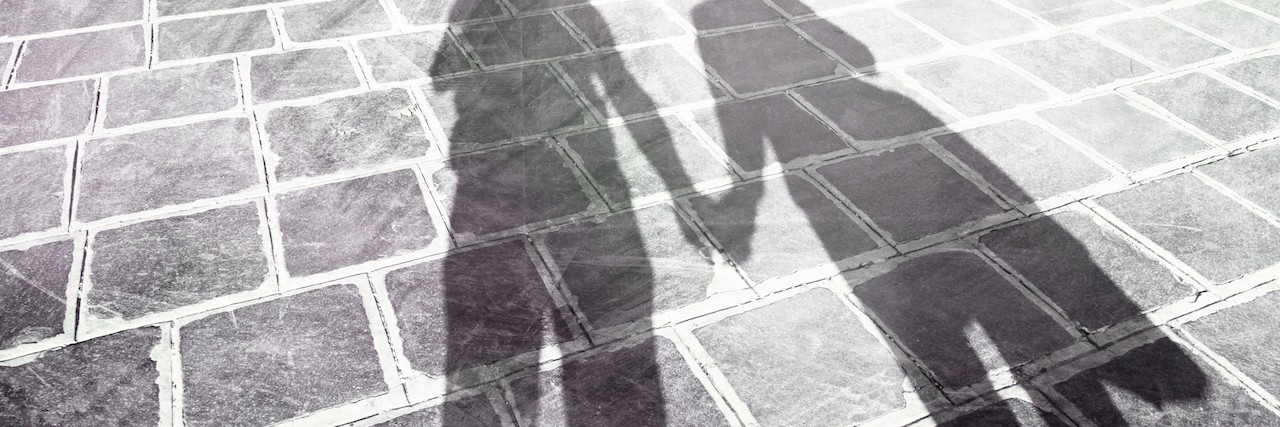 shadows of two people holding hands