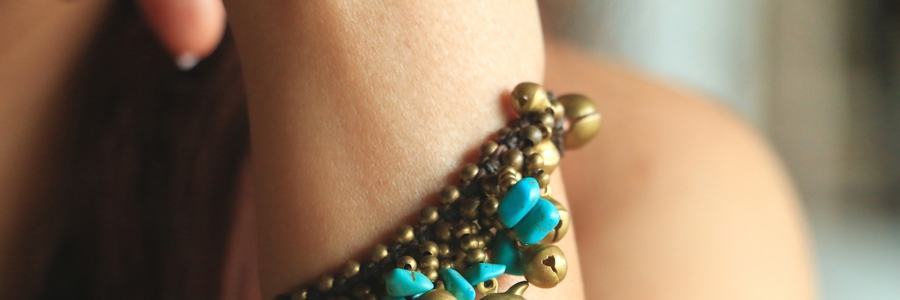 What Happens When People Notice Your Self-Harm Scars close up on a woman's wrist wearing a bracelet